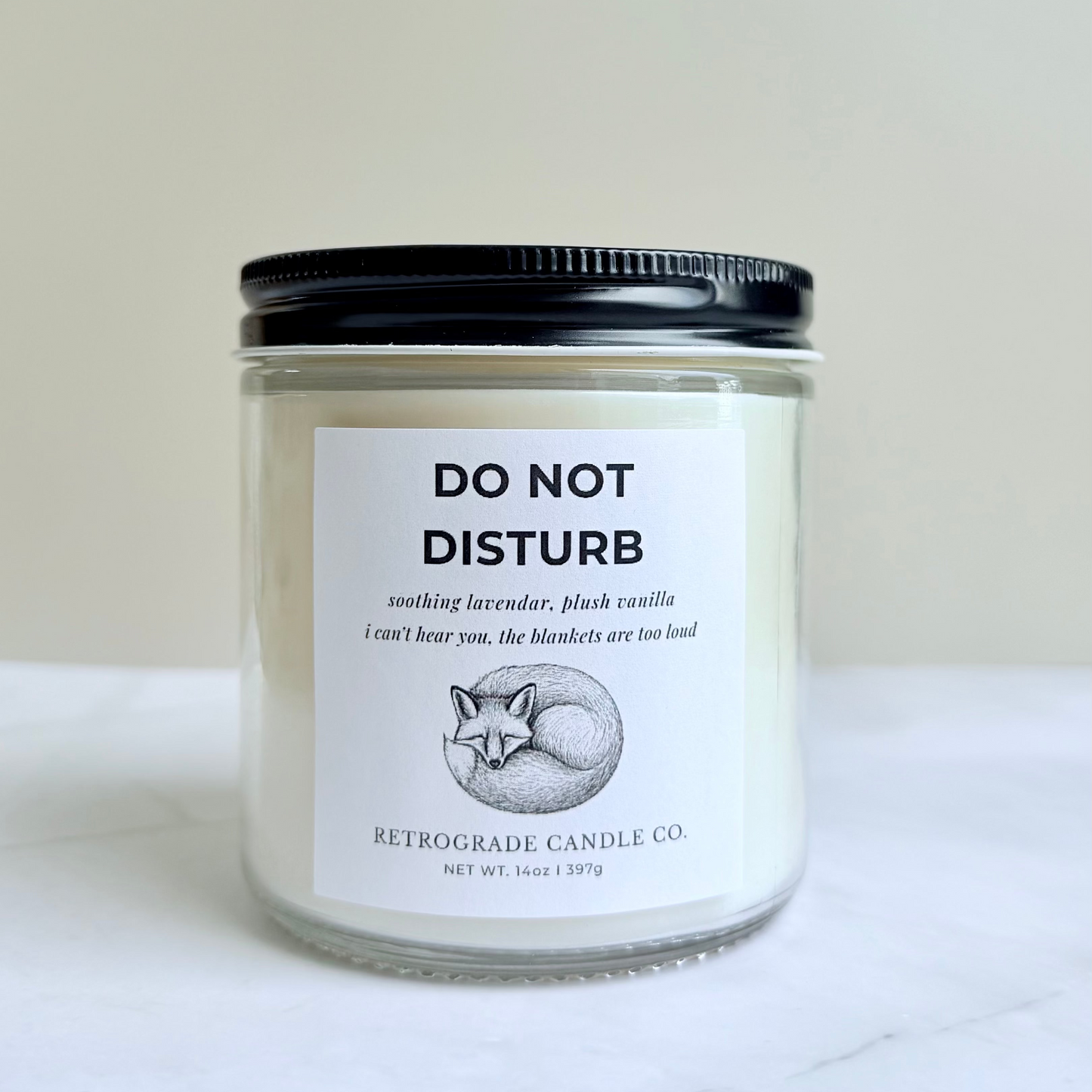 Candle jar labeled 'Do Not Disturb' on a marble surface with a neutral background