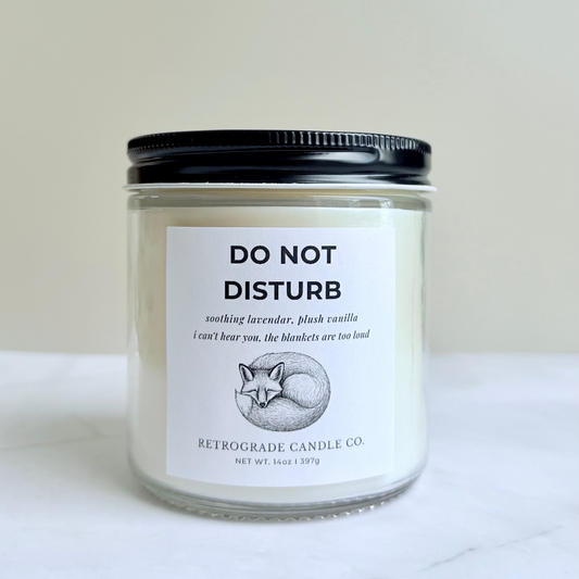 Candle jar labeled 'Do Not Disturb' on a marble surface with a neutral background